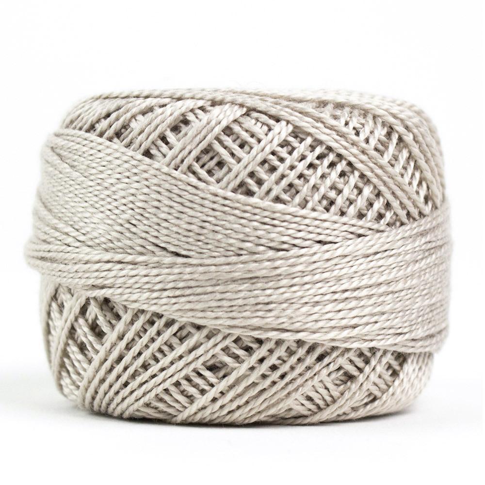 Side view of Perle cotton ball on white background to show color