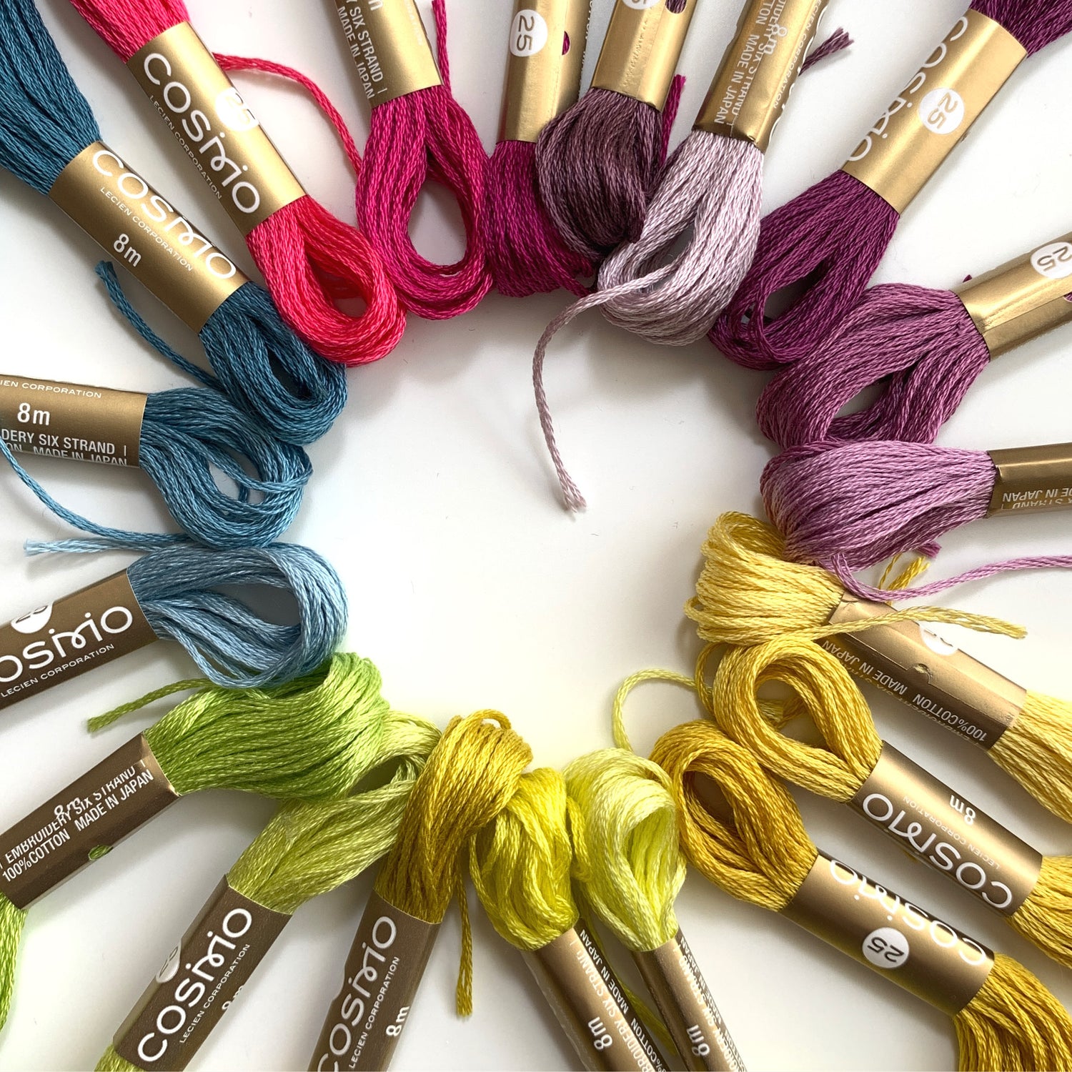 Cosmo 6-strand floss in a ring with hues fading from purple to yellow to green to blue to red
